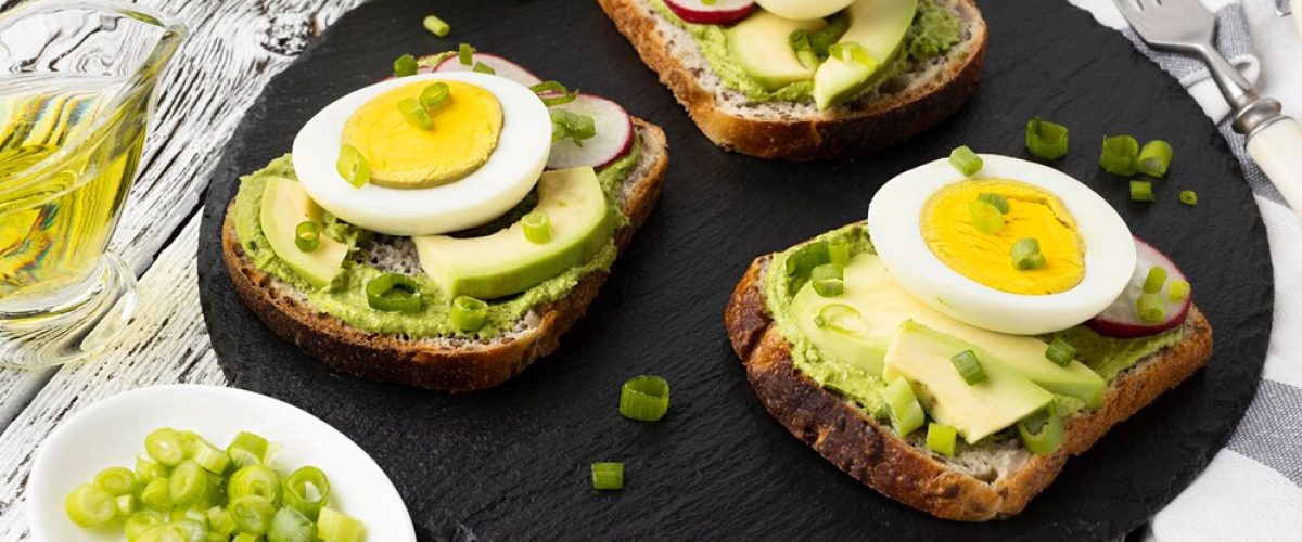 high-angle-sandwiches-slate-with-egg-avocado_23-2148640212